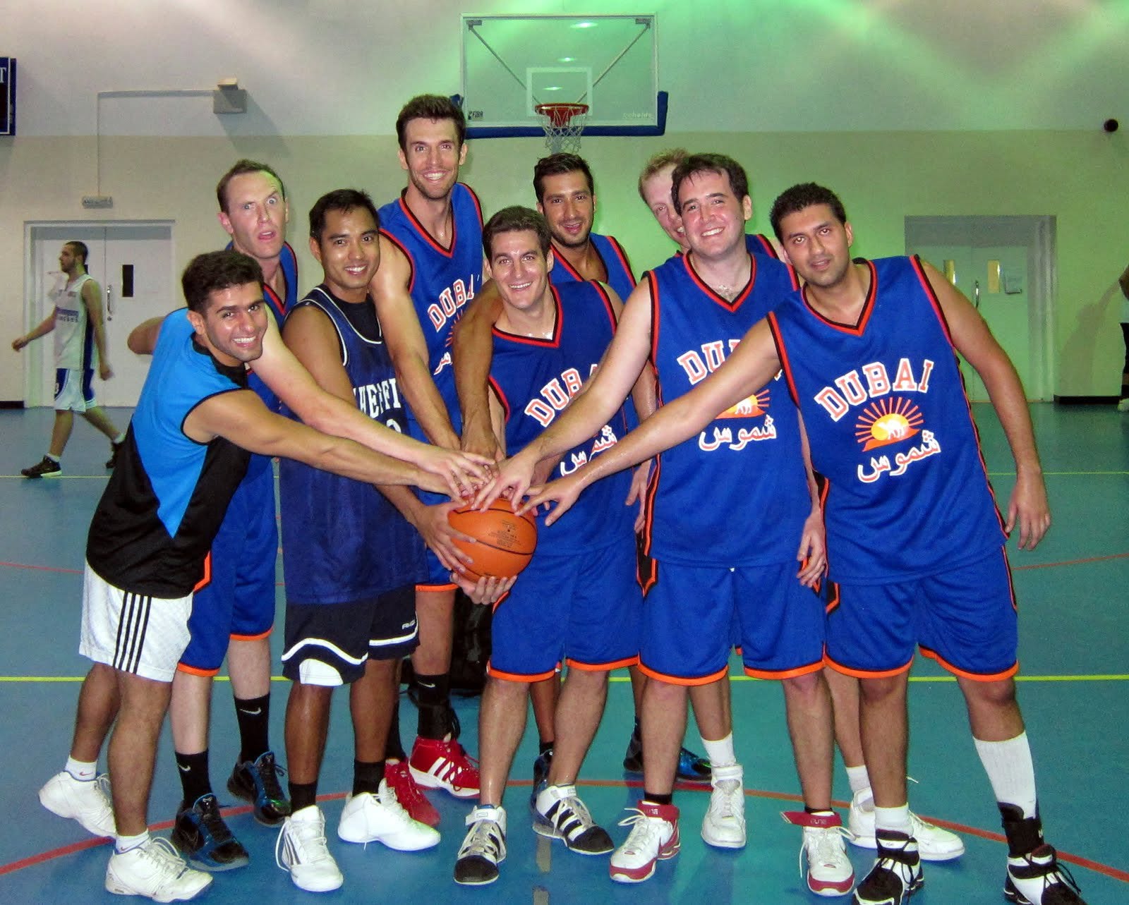 Brian Sigafoos and his Dubai recreational league teammates huddling around a basketball